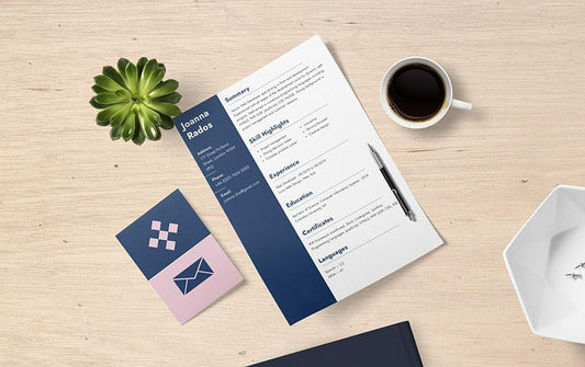 A resume on a desk with a pen, a cup of coffee and a plant.